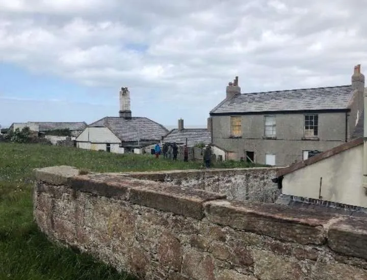 Hilbre’s telegraph station and cottages behind an old sandstone wall